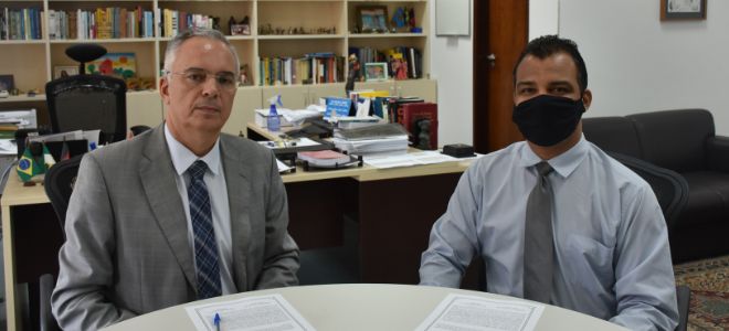 Imagem Foto da posse. O juiz federal Manuel Maia e o servidor Weverton John Moreira sentados, da esquerda para a direita.