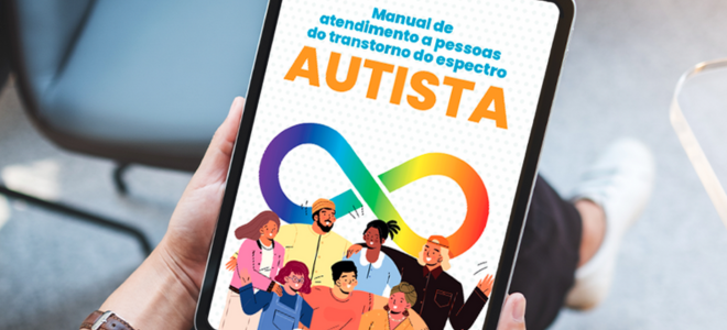 Imagem A imagem mostra uma pessoa segurando um tablet que exibe a capa do “Manual de atendimento a pessoas do transtorno do espectro autista”. No centro da capa, há um símbolo do infinito com as cores do arco-íris, representando a diversidade dentro do espectro autista. Abaixo do símbolo, estão ilustrações de pessoas diversas, com expressões alegres e acolhedoras, simbolizando inclusão e empatia. O título destaca a palavra “AUTISTA” em letras maiúsculas e laranja, com o restante do texto em azul. 